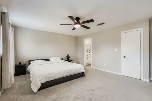 a bedroom with a bed and a ceiling fan