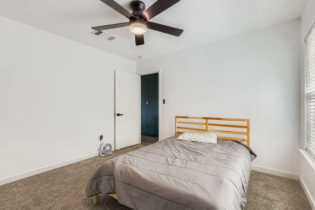 a bedroom with a bed and a ceiling fan
