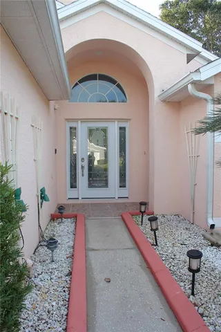 a view of a hallway with windows and chandelier