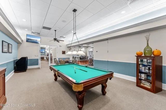 a room with pool table and windows
