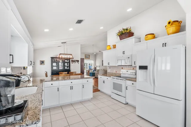 a kitchen with white cabinets and white appliances