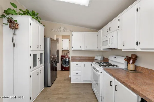 a kitchen with stainless steel appliances white cabinets and a refrigerator
