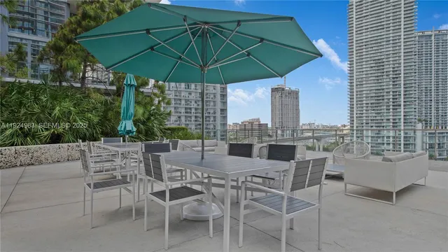 a view of a patio with a table and chairs under an umbrella