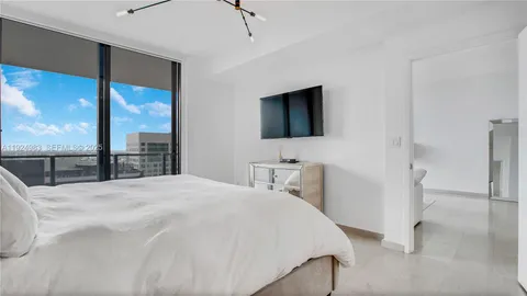 a bedroom with a bed and a flat screen tv