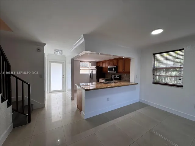 a living room with stainless steel appliances kitchen island hardwood floor and a sink