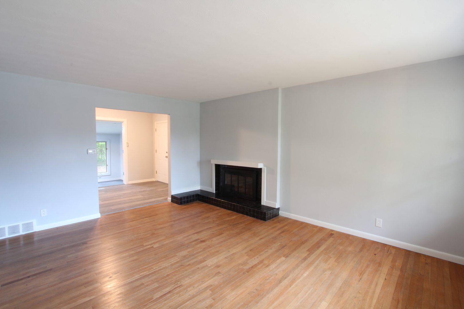 703 Sheridan Road Normal, IL 61761 - Photo 2 of 15 a view of empty room with wooden floor and fireplace