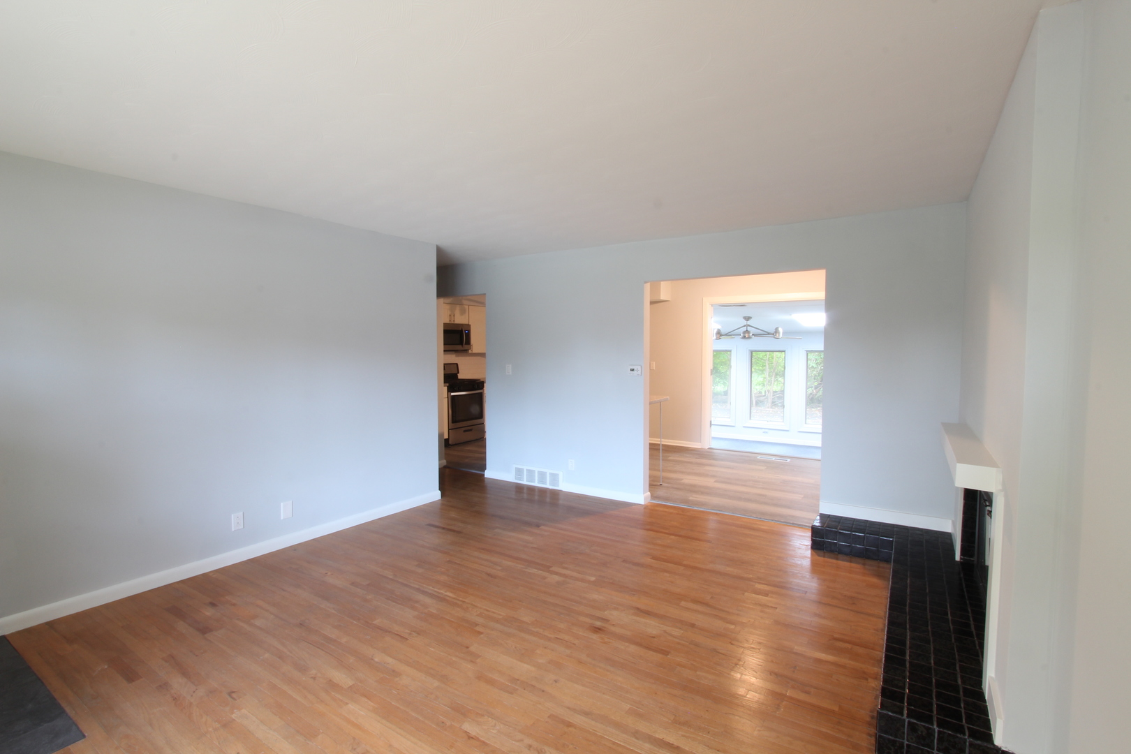 703 Sheridan Road Normal, IL 61761 - Photo 3 of 15 a view of an empty room with wooden floor and a window