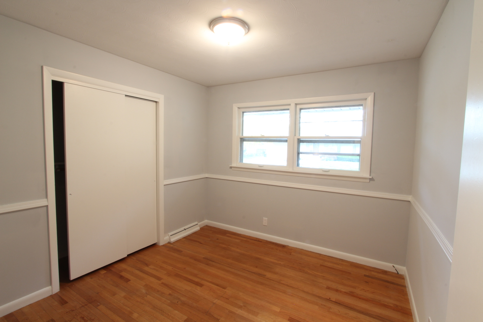 703 Sheridan Road Normal, IL 61761 - Photo 8 of 15 an empty room with wooden floor and windows