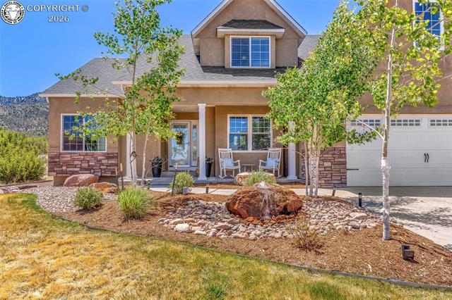 The front yard was professionally updated in 2024 and features beautiful fully irrigated landscaping with three Aspen trees, a Ponderosa Pine, shrubs, lush grass, and a custom boulder water fountain that creates an inviting and welcoming first impression.