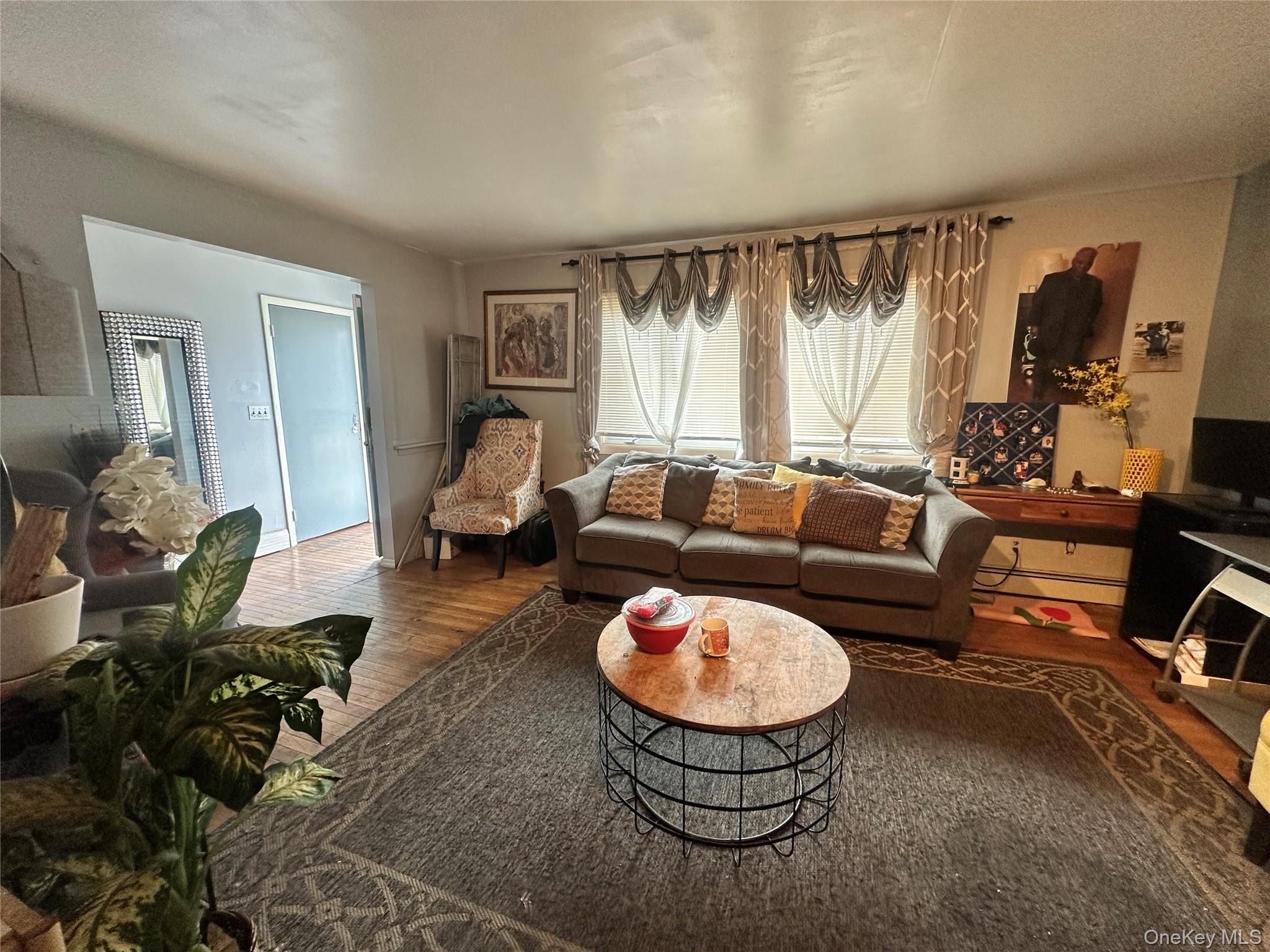 16 Spring Street Roosevelt, NY 11575 - Photo 11 of 19 a living room with furniture a rug and a window