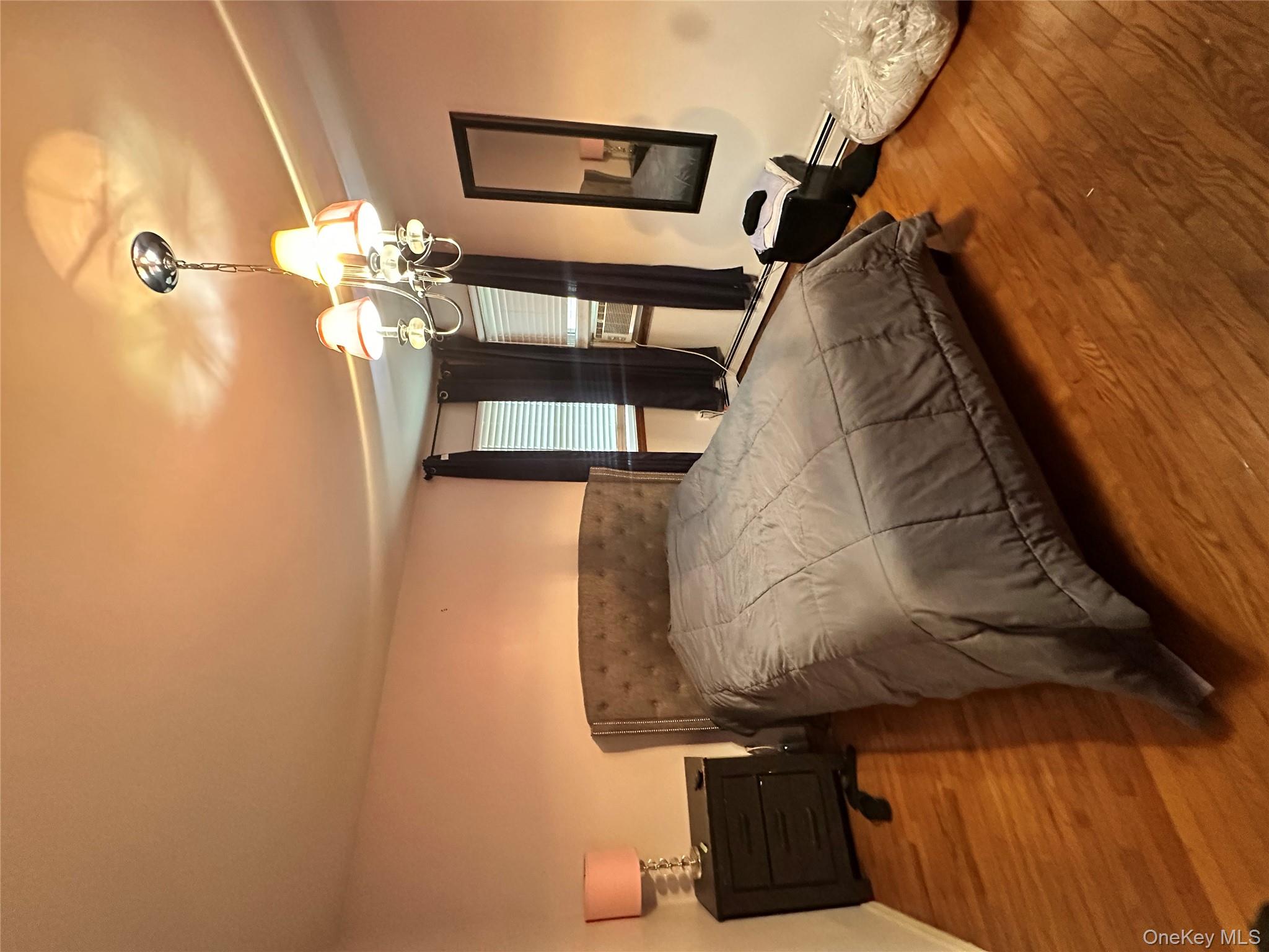 16 Spring Street Roosevelt, NY 11575 - Photo 16 of 19 a bedroom with a bed and wooden floor