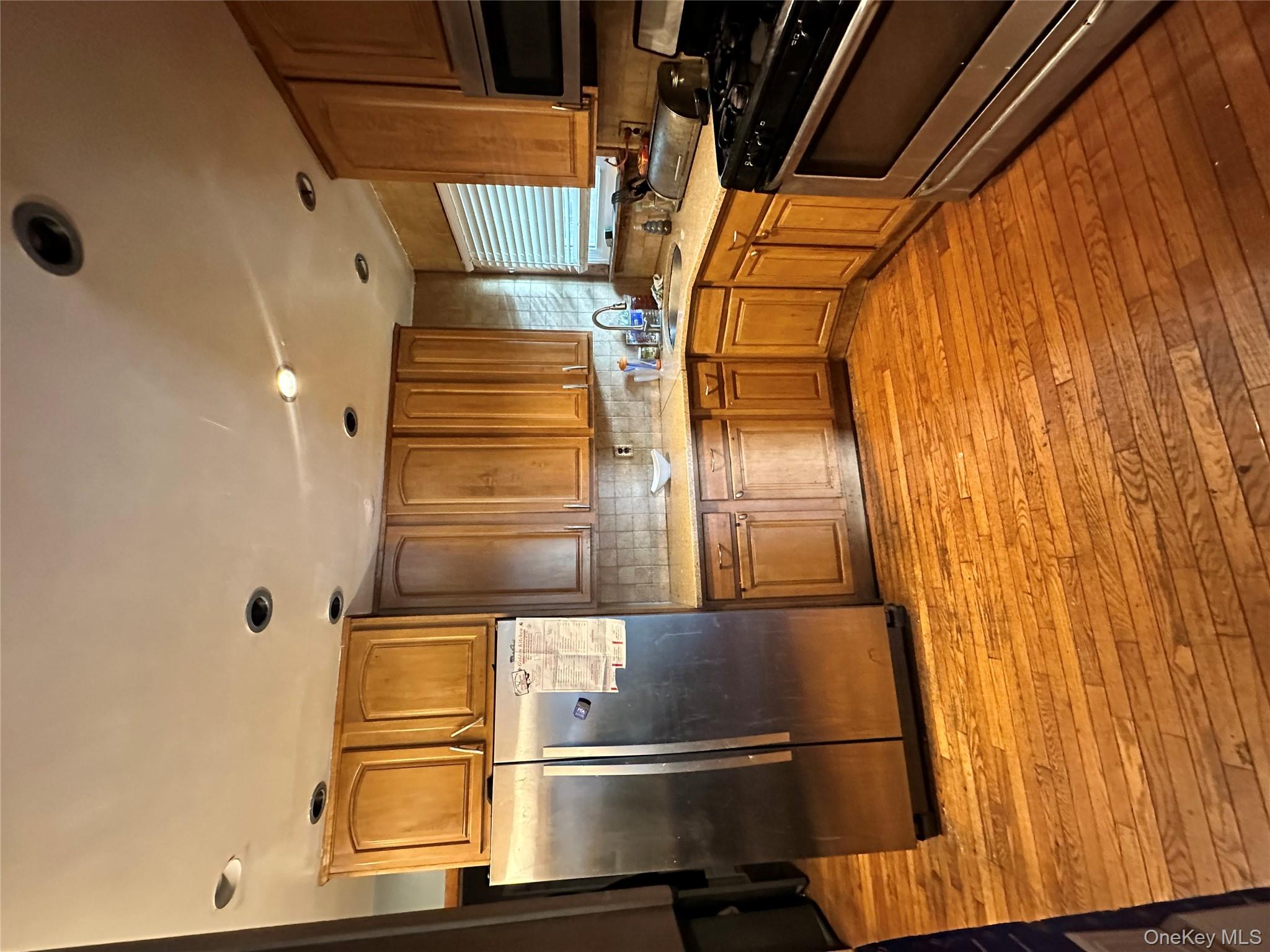 16 Spring Street Roosevelt, NY 11575 - Photo 17 of 19 a kitchen with stainless steel appliances granite countertop a refrigerator sink and cabinets