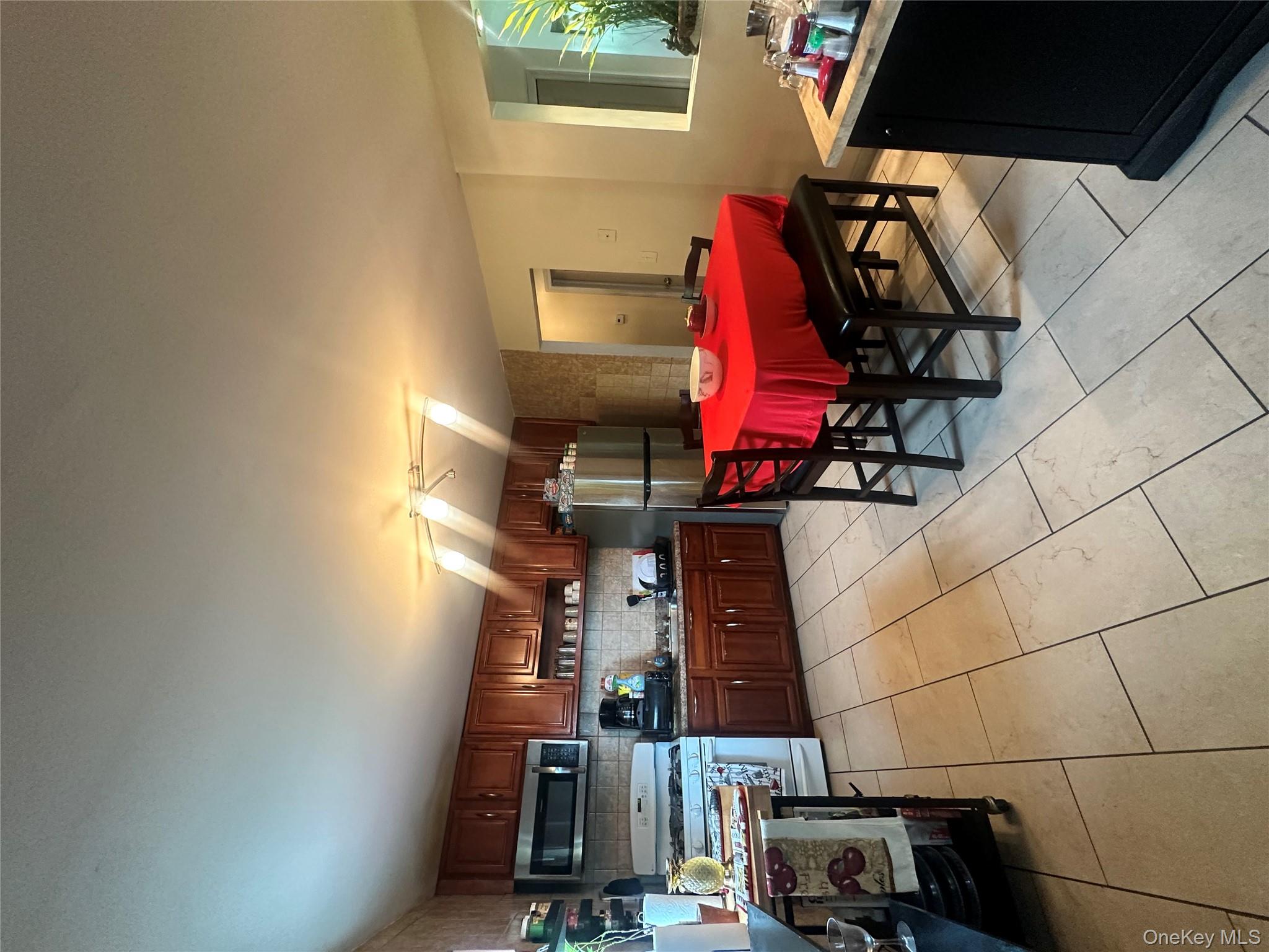 16 Spring Street Roosevelt, NY 11575 - Photo 3 of 19 a kitchen with stainless steel appliances kitchen island granite countertop a refrigerator and stove