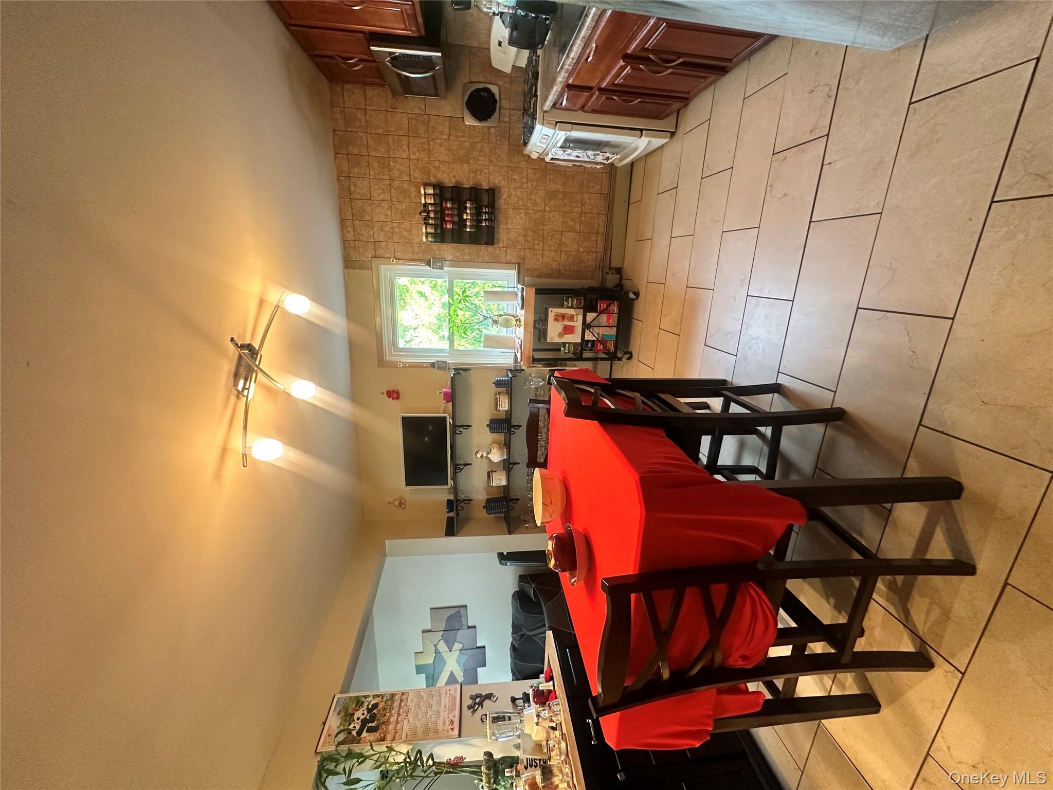 16 Spring Street Roosevelt, NY 11575 - Photo 4 of 19 a kitchen with stainless steel appliances a sink counter space and a view of living room