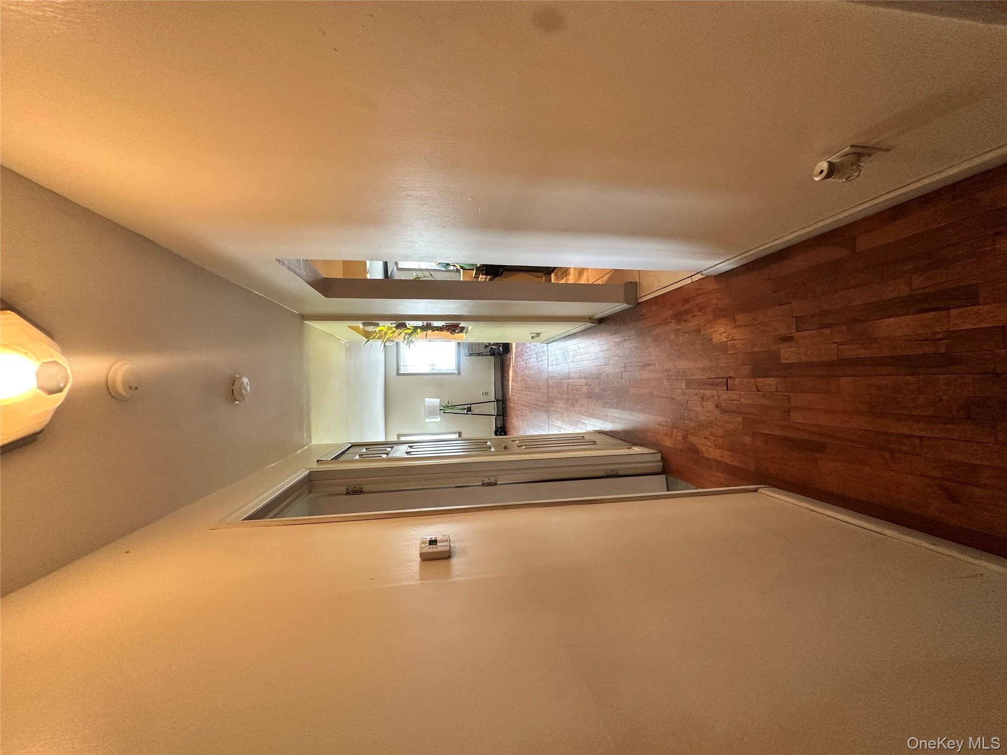 16 Spring Street Roosevelt, NY 11575 - Photo 8 of 19 a view of a hallway with wooden floor