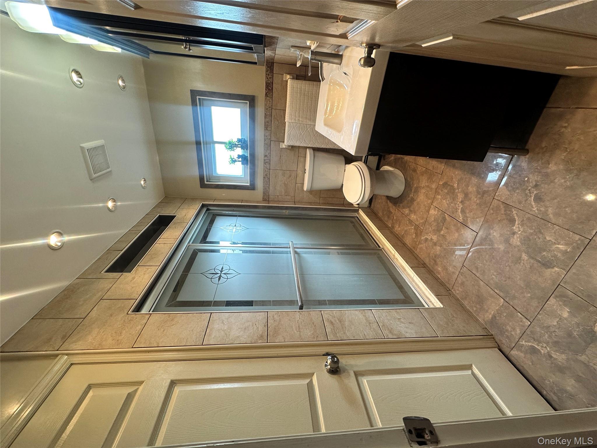 16 Spring Street Roosevelt, NY 11575 - Photo 9 of 19 a bathroom with a sink toilet and shower