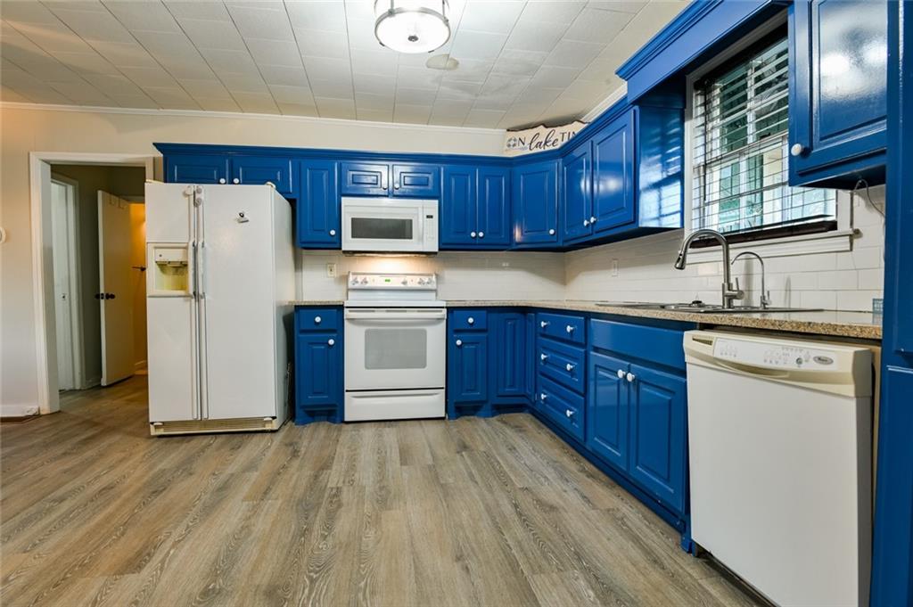 458 Haley Road Jackson, GA 30233 - Photo 8 of 47 a kitchen with stainless steel appliances granite countertop a refrigerator a sink dishwasher and wooden cabinets with wooden floor