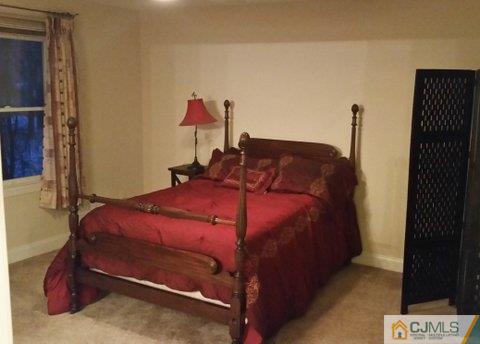 16 Parker Road Edison, NJ 08820 - Photo 16 of 25 a bed sitting in a bedroom next to a cabinet