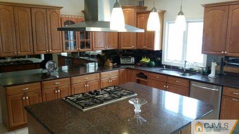 16 Parker Road Edison, NJ 08820 - Photo 5 of 25 a kitchen with stainless steel appliances granite countertop a sink stove and cabinets