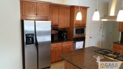 16 Parker Road Edison, NJ 08820 - Photo 7 of 25 a kitchen with stainless steel appliances granite countertop a refrigerator and a stove