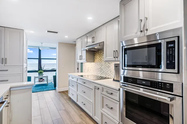 a kitchen with stainless steel appliances kitchen island granite countertop a stove and a sink