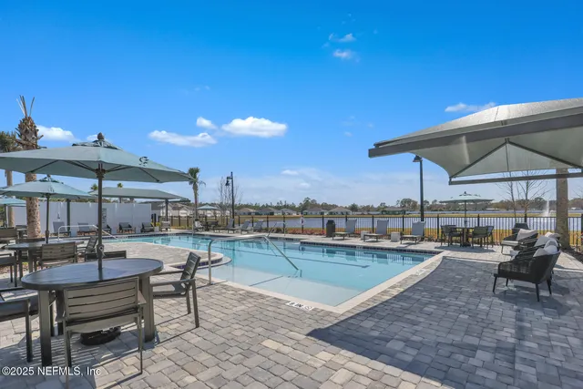 a view of a patio with chairs and a table under an umbrella