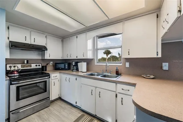 a kitchen with a sink stove and cabinets