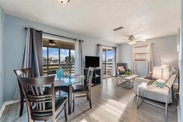 a living room with furniture flat screen tv and a large window