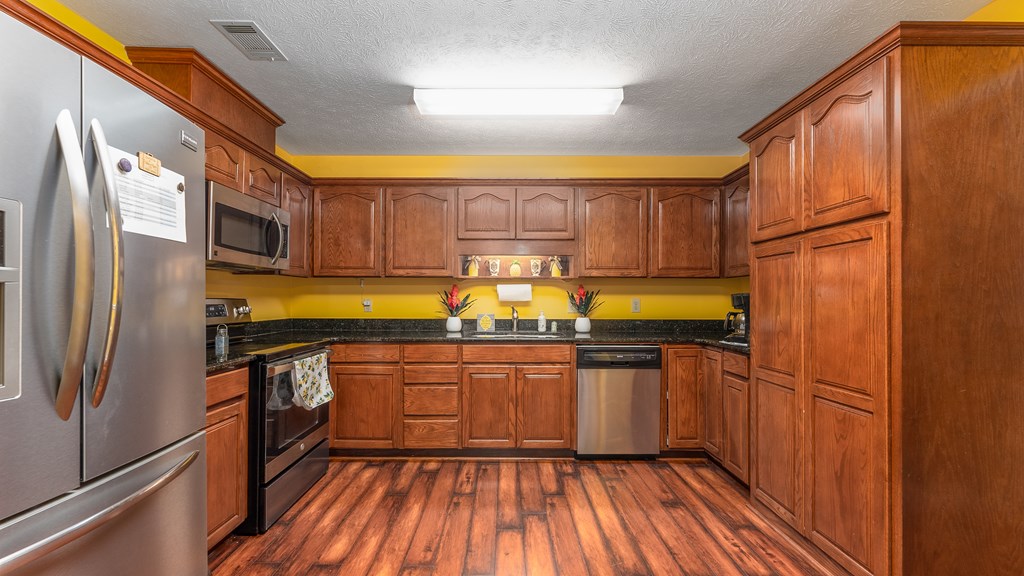 4420 Reese Road, Unit 1D Columbus, GA 31907 - Photo 4 of 17 a kitchen with stainless steel appliances granite countertop a refrigerator a sink dishwasher a stove and white countertops with wooden floor