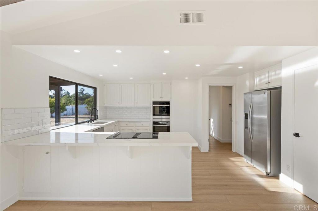 112 Palmas Norte Fallbrook, CA 92028 - Photo 26 of 74 a large kitchen with stainless steel appliances a large counter top a refrigerator and a sink