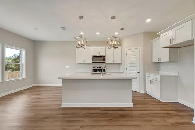 a view of a kitchen with kitchen island a sink stainless steel appliances and cabinets