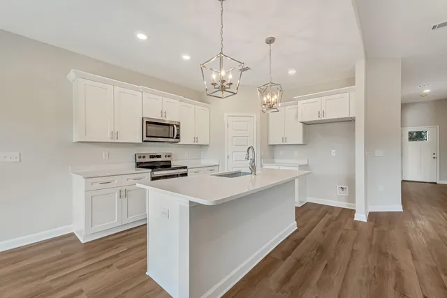 a kitchen with a sink stainless steel appliances and white cabinets