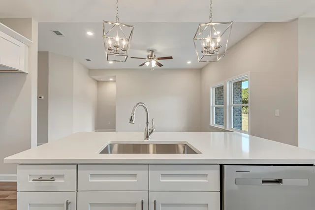 a view of a kitchen with a sink and chandelier