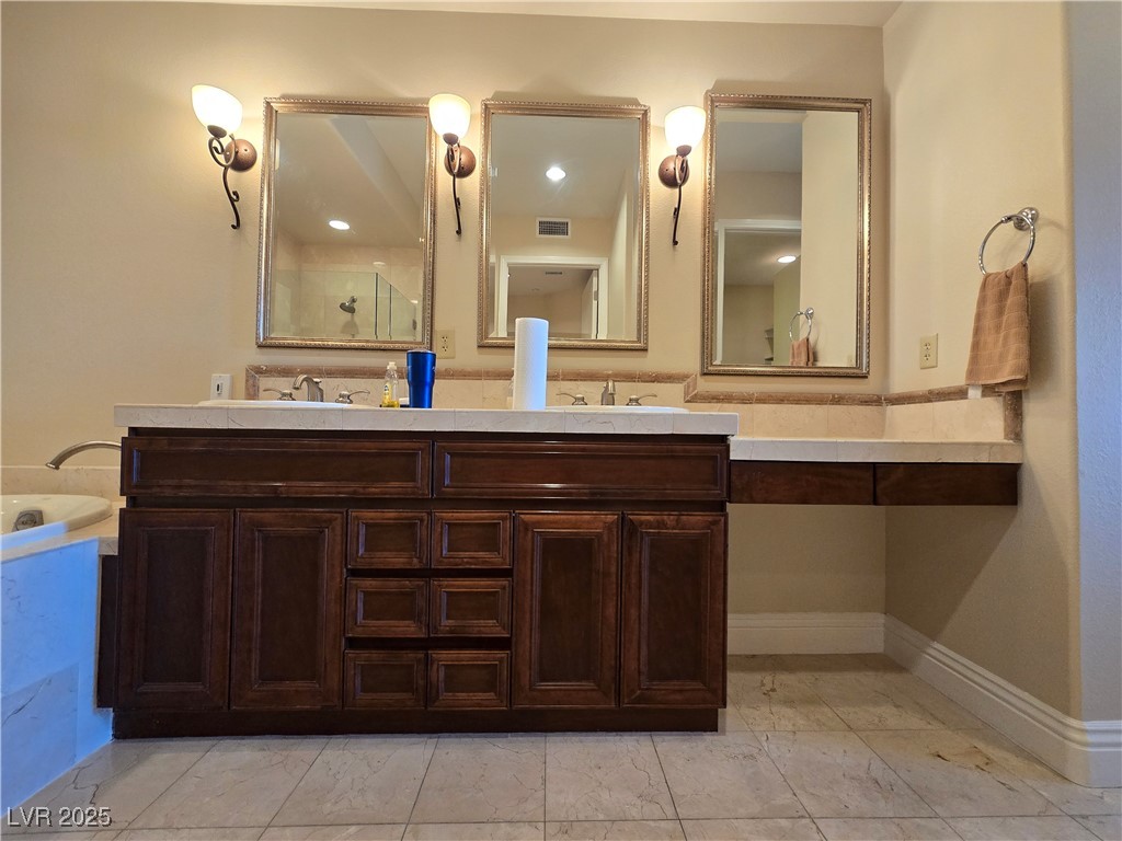 20 Via Mantova, Unit 202 Henderson, NV 89011 - Photo 47 of 60 Full bathroom featuring double vanity, marble look tiles, and a bath