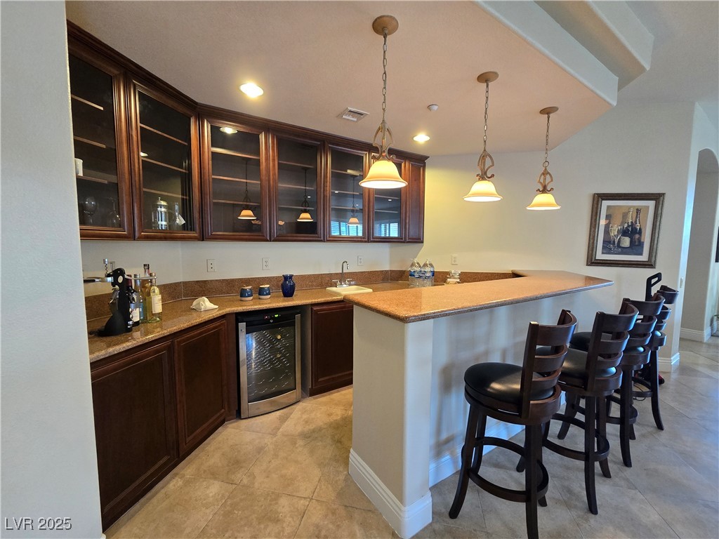 20 Via Mantova, Unit 202 Henderson, NV 89011 - Photo 8 of 60 Indoor wet bar with beverage cooler, hanging light fixtures, light tile patterned flooring, and recessed lighting
