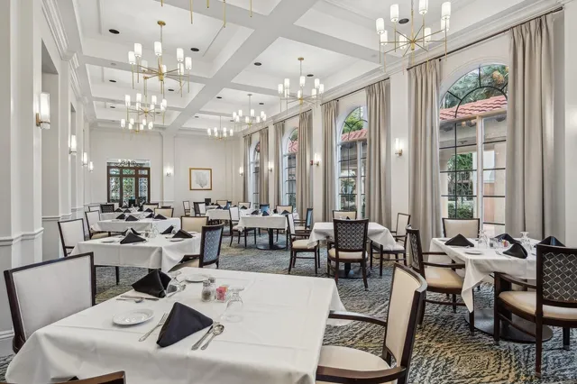 a living room with lots of white furniture and a chandelier