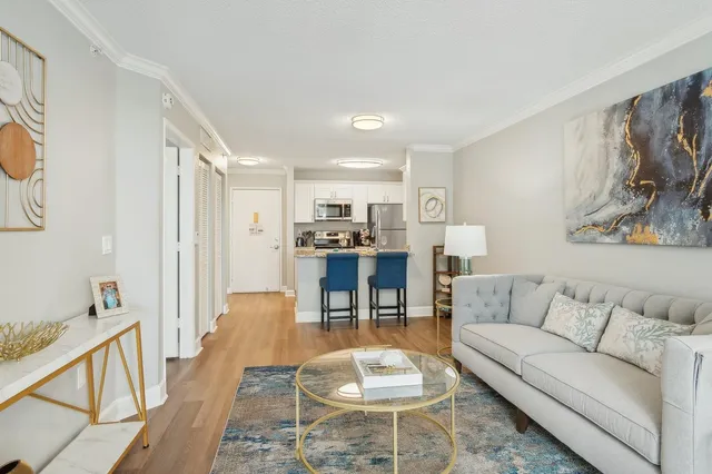 a living room with furniture and a dining table with kitchen view
