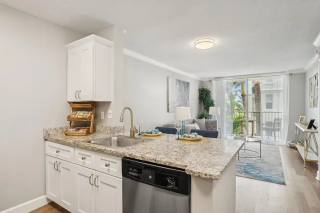 a kitchen with granite countertop stainless steel appliances sink stove and cabinets
