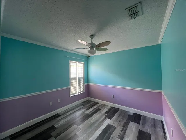 a view of a room with a ceiling fan and window