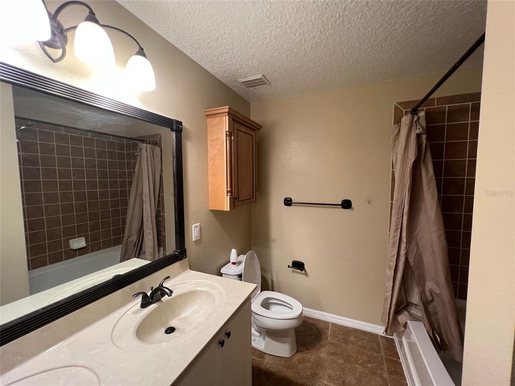 2570 Wild Tamarind Boulevard Orlando, FL 32828 - Photo 17 of 20 a bathroom with a sink a toilet and shower