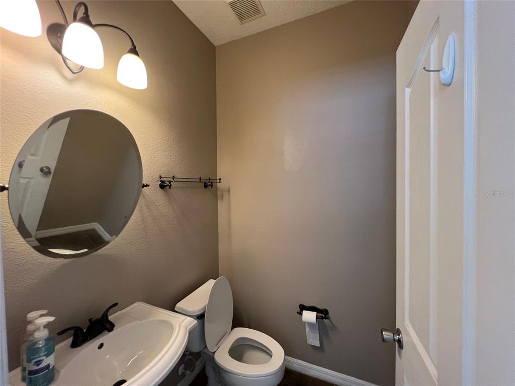 2570 Wild Tamarind Boulevard Orlando, FL 32828 - Photo 10 of 20 a bathroom with a toilet sink and mirror