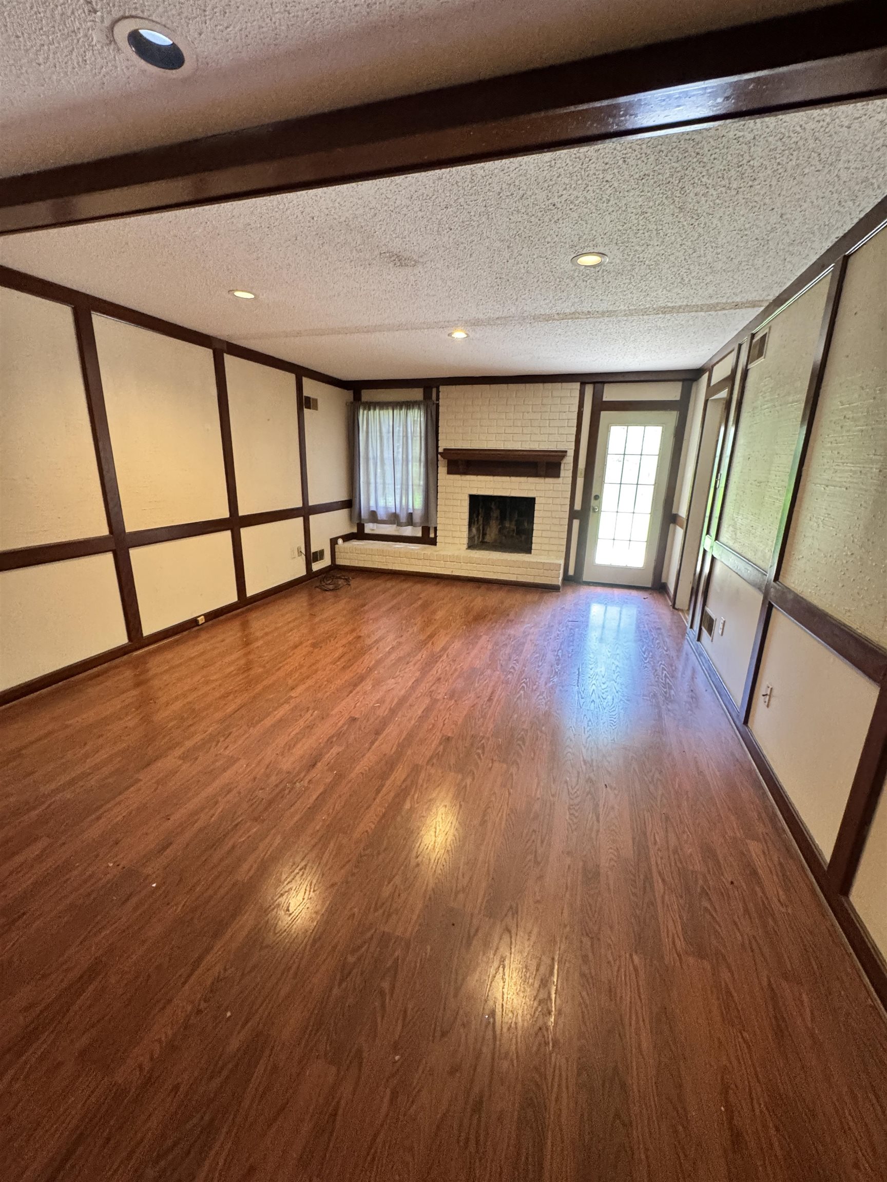 4334 Timber Rise Road Memphis, TN 38125 - Photo 5 of 18 Spacious interior featuring wood-finish flooring, a white brick fireplace with a wood mantel, recessed lighting, and a glass-paneled exterior door