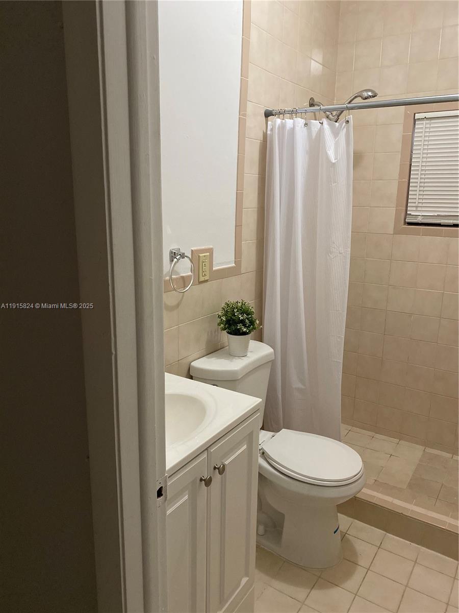 2140 Southwest 25th Street, Unit A Miami, FL 33133 - Photo 2 of 8 a white toilet sitting next to a bathroom sink