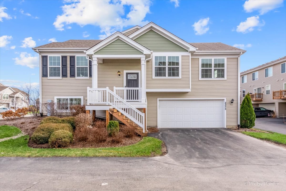 2375 Upland Road Pingree Grove, IL 60140 - Photo 1 of 32 a front view of a house with a yard and garage