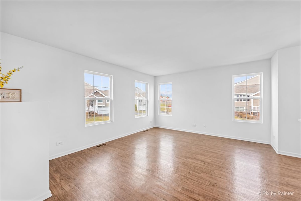 2375 Upland Road Pingree Grove, IL 60140 - Photo 3 of 32 a view of an empty room with wooden floor and a window