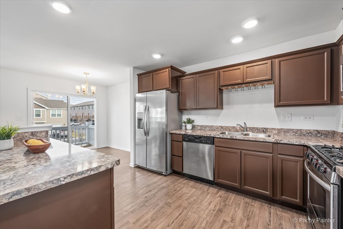 2375 Upland Road Pingree Grove, IL 60140 - Photo 6 of 32 a kitchen with stainless steel appliances granite countertop a sink stove and refrigerator