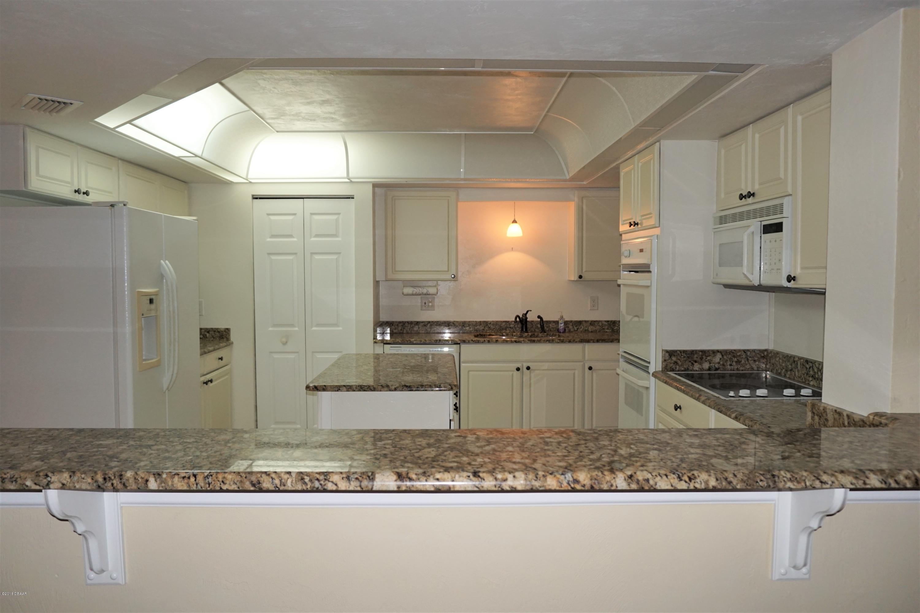 1 John Anderson Drive, Unit 113 Ormond Beach, FL 32176 - Photo 14 of 76 a kitchen with a refrigerator and a stove