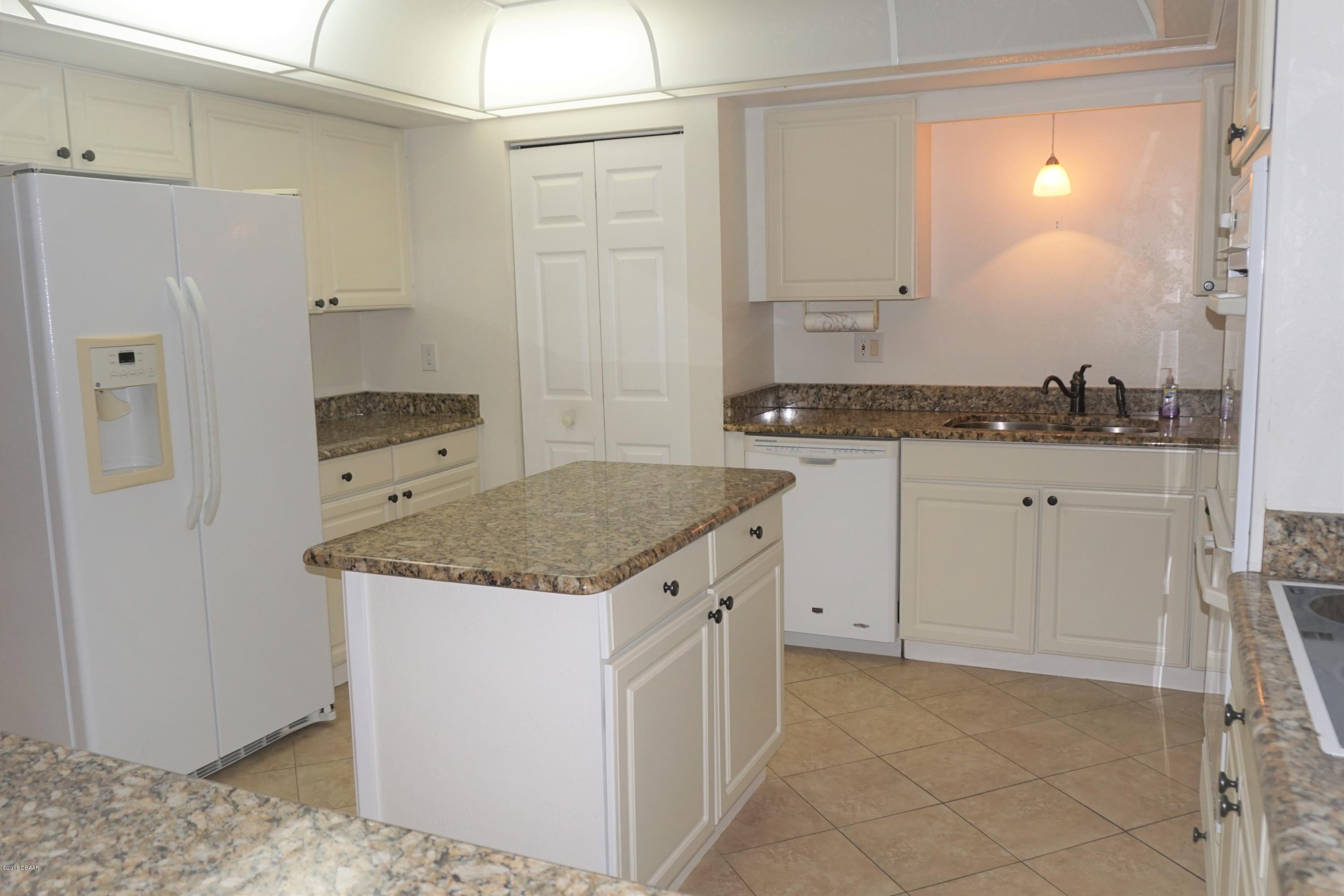 1 John Anderson Drive, Unit 113 Ormond Beach, FL 32176 - Photo 16 of 76 a kitchen with granite countertop a sink and cabinets