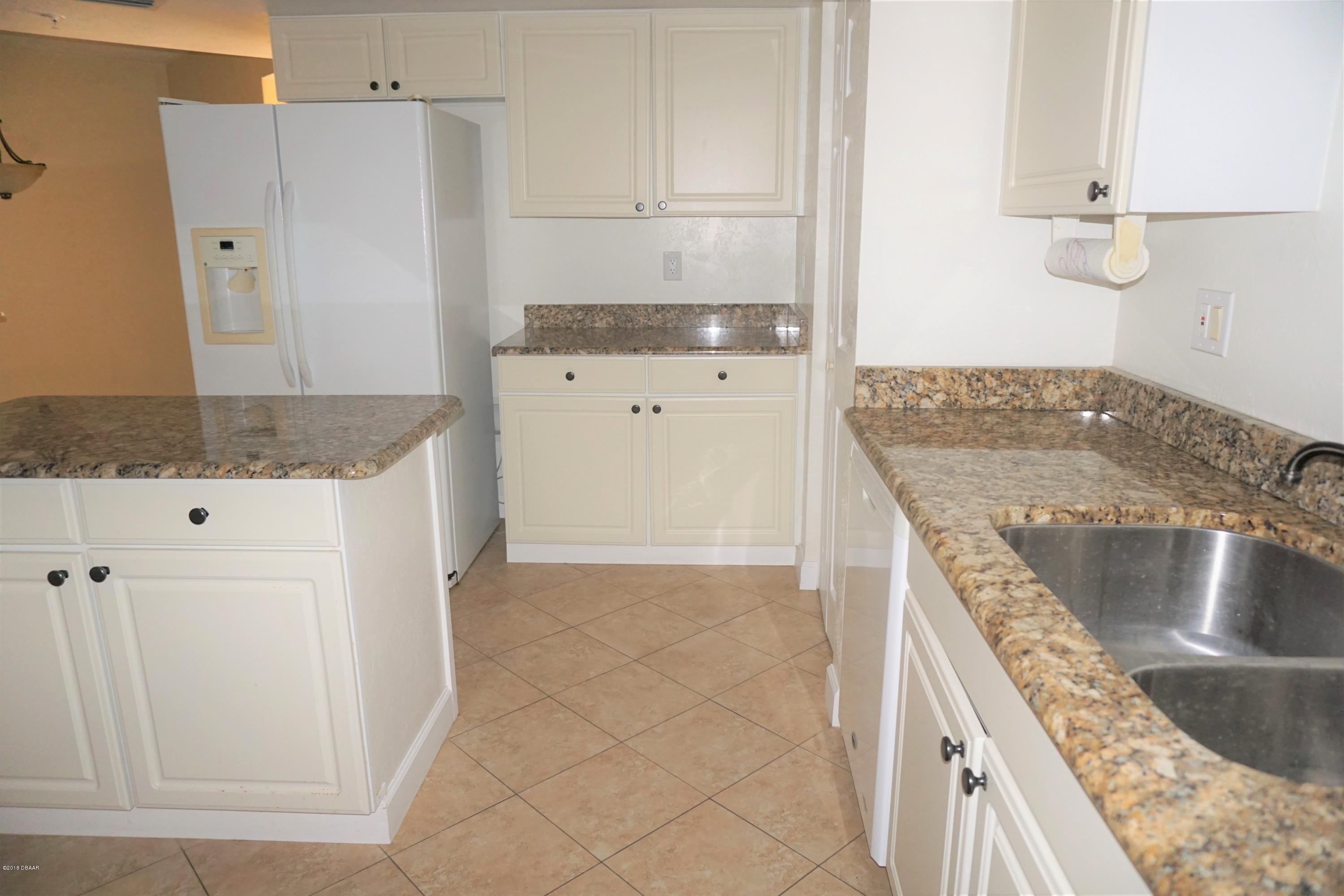 1 John Anderson Drive, Unit 113 Ormond Beach, FL 32176 - Photo 18 of 76 a kitchen with a stove a sink and a refrigerator