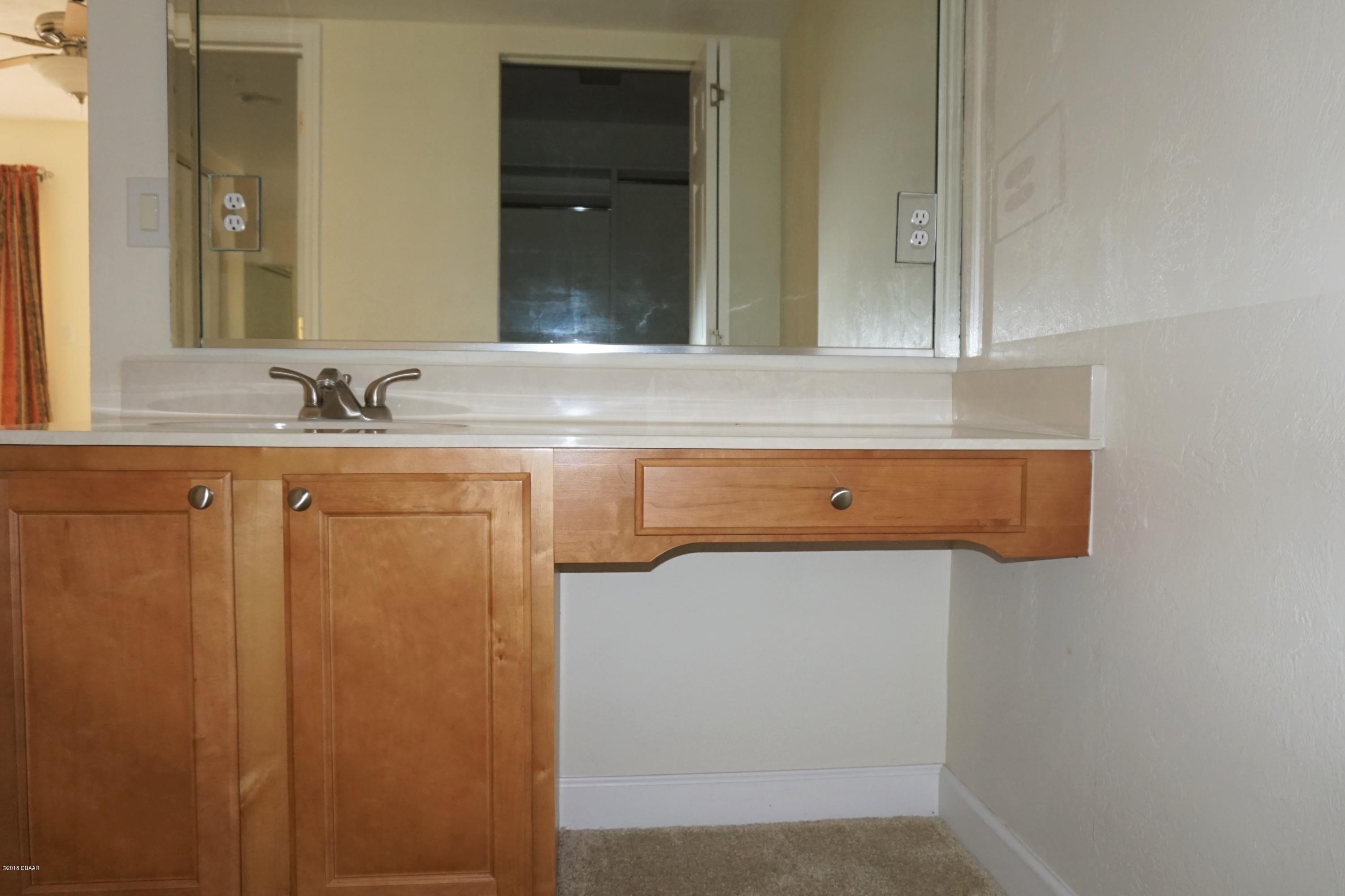 1 John Anderson Drive, Unit 113 Ormond Beach, FL 32176 - Photo 22 of 76 a bathroom with a sink and a mirror